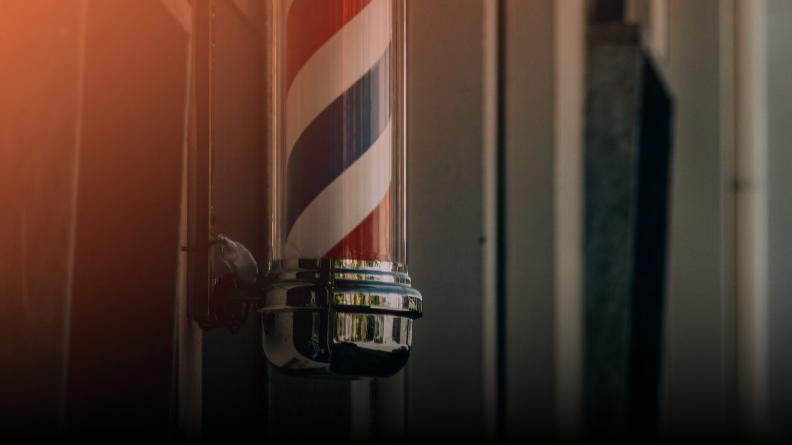 A striped barber pole outside a barbershop