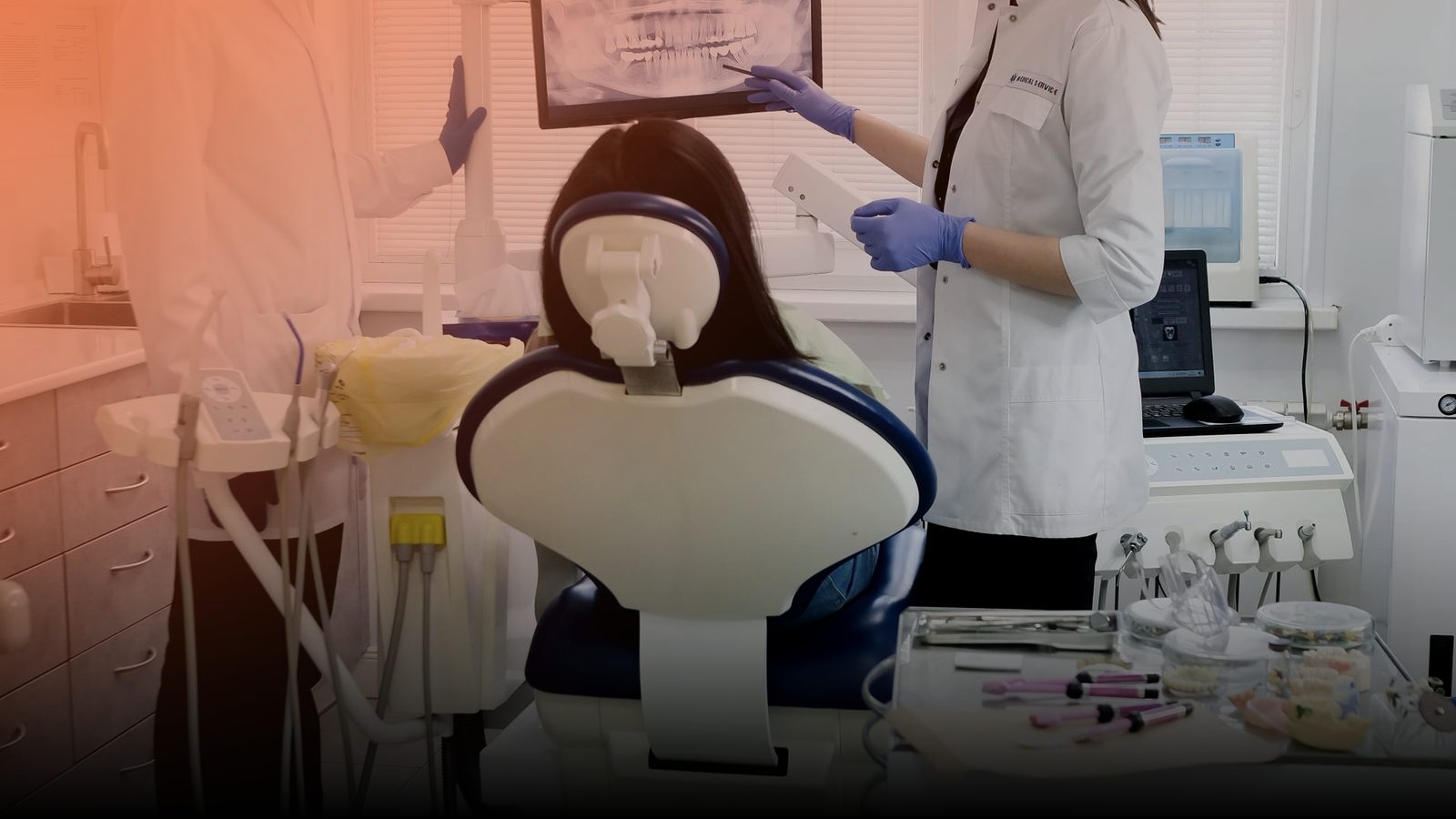 Two dentists reviewing an X-ray on a monitor in a clinic