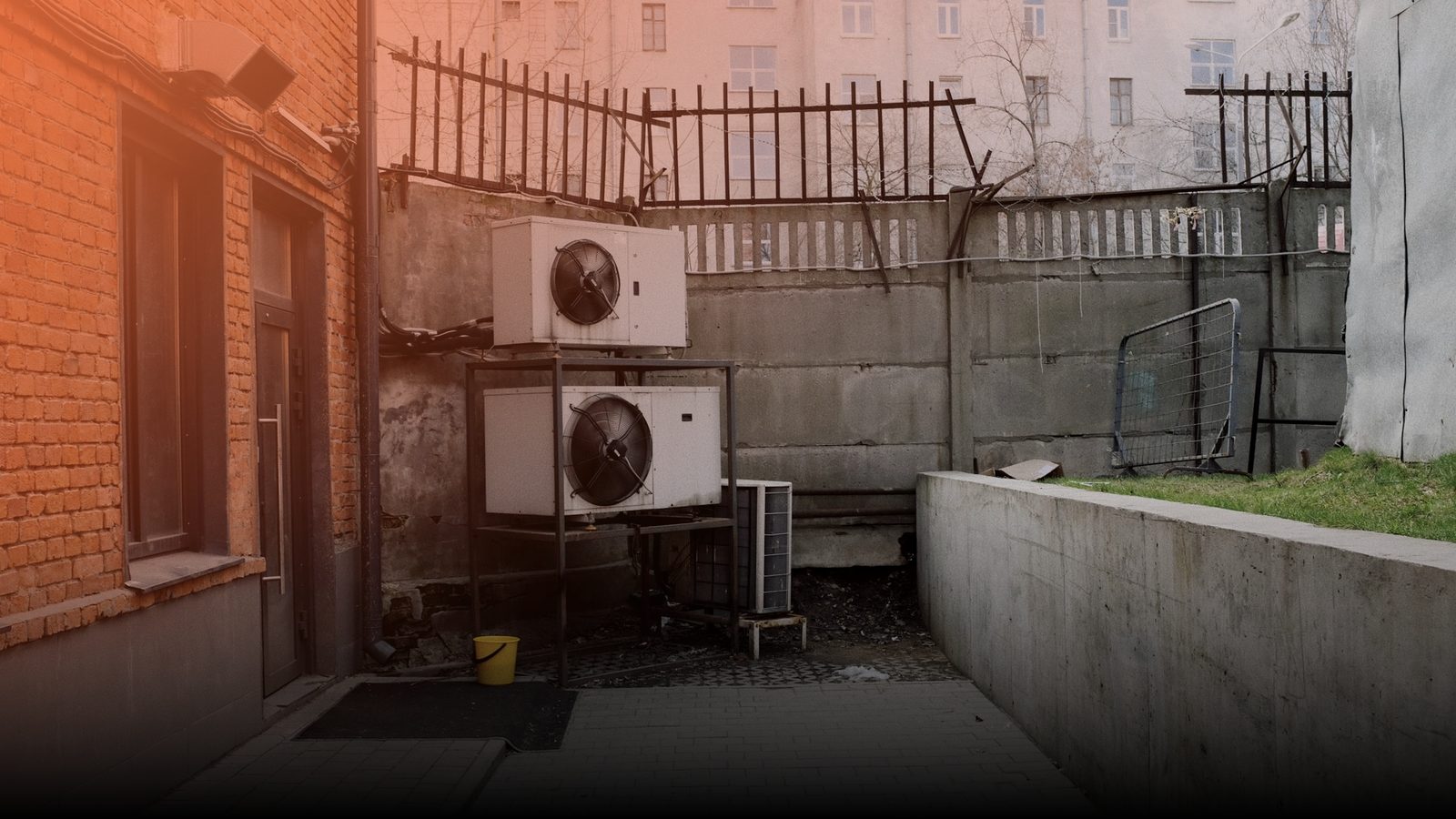 Air conditioning condenser units mounted on the wall of a brick building