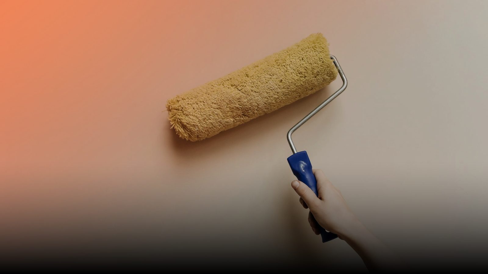 A painter rolling fresh paint onto a wall with a roller