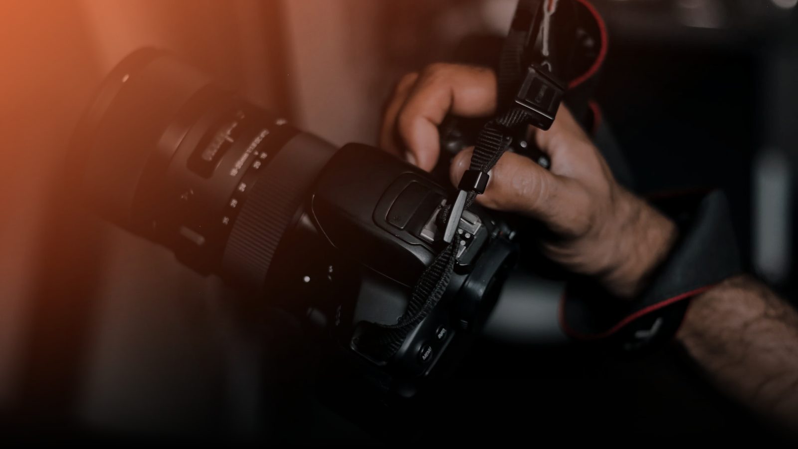 A photographer holding a camera fitted with a long lens