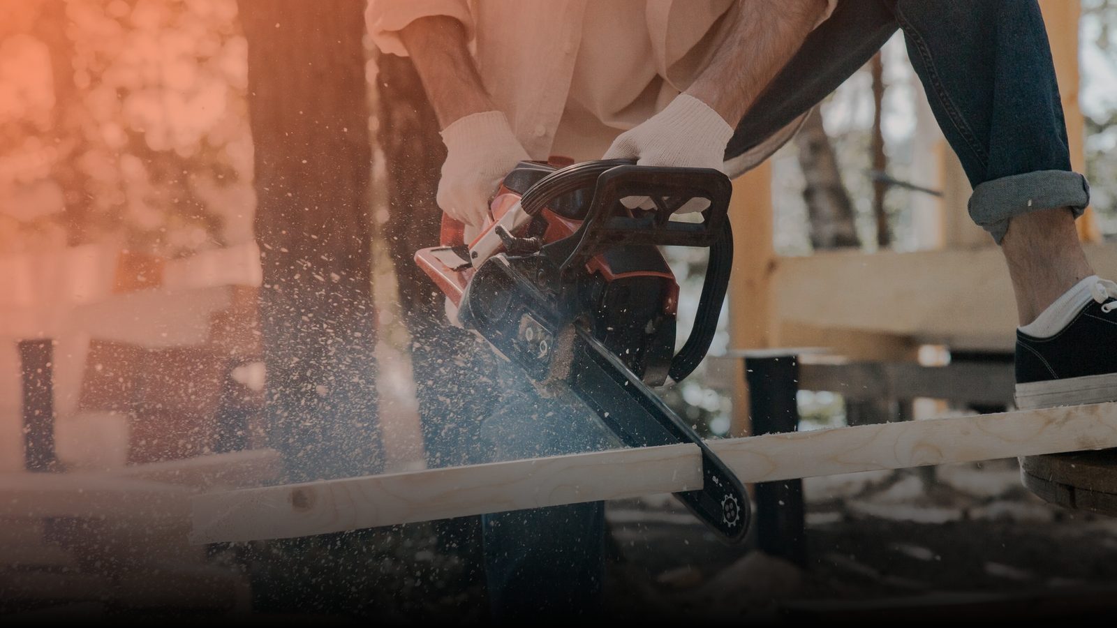 An arborist cutting through a log with a chainsaw